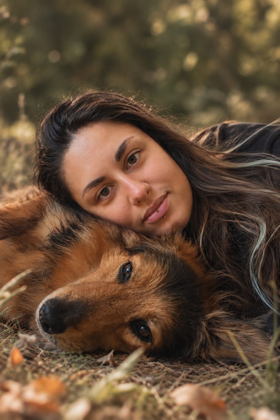 Sosso allongée dans l'herbe, la tête contre celle de sa chienne Alba